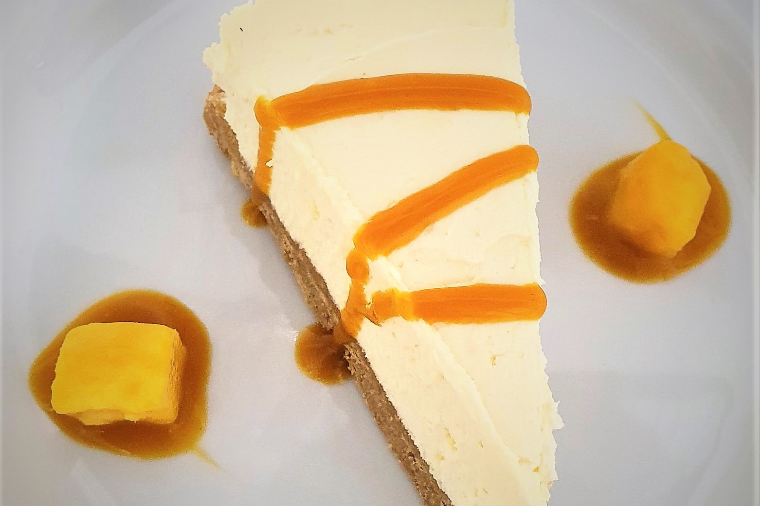 Homemade vanilla cheesecake with mango coulis