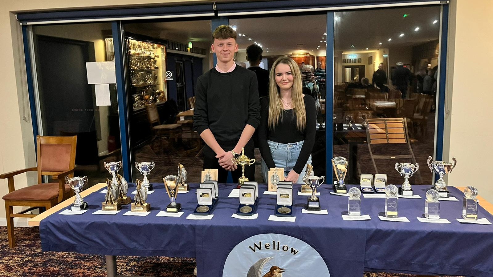 Past Captain Emma Chester and Incoming 2024/25 Captain Farren Porter Pose in front of the Trophies available to win this season