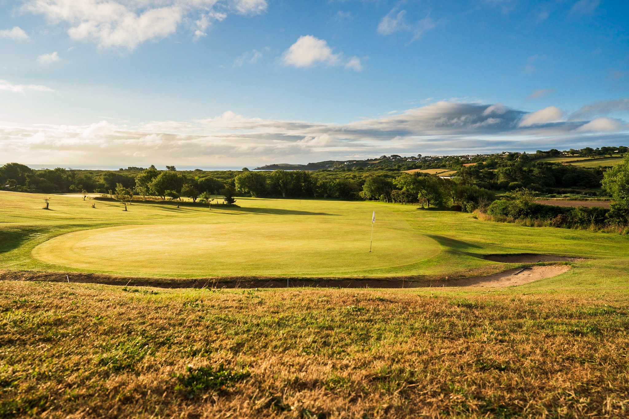 The highest part of the course, the 15th green with views back over the trees to the sea.